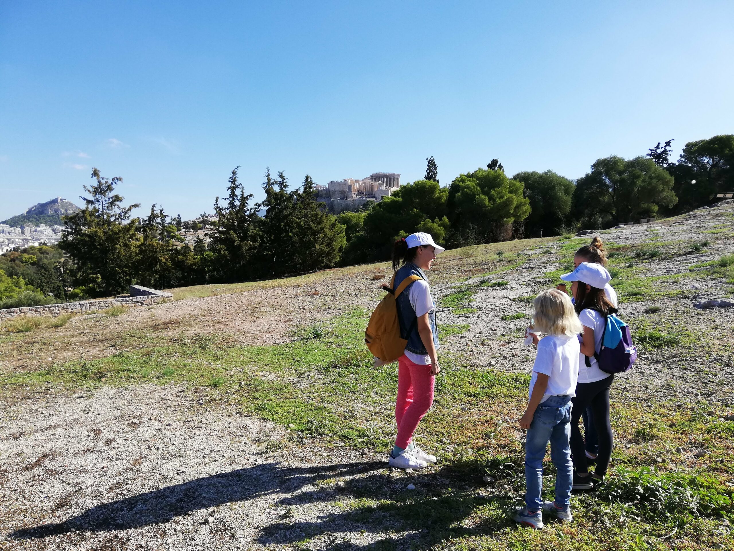 Pnyx hill with the kids and Acropolis in the background