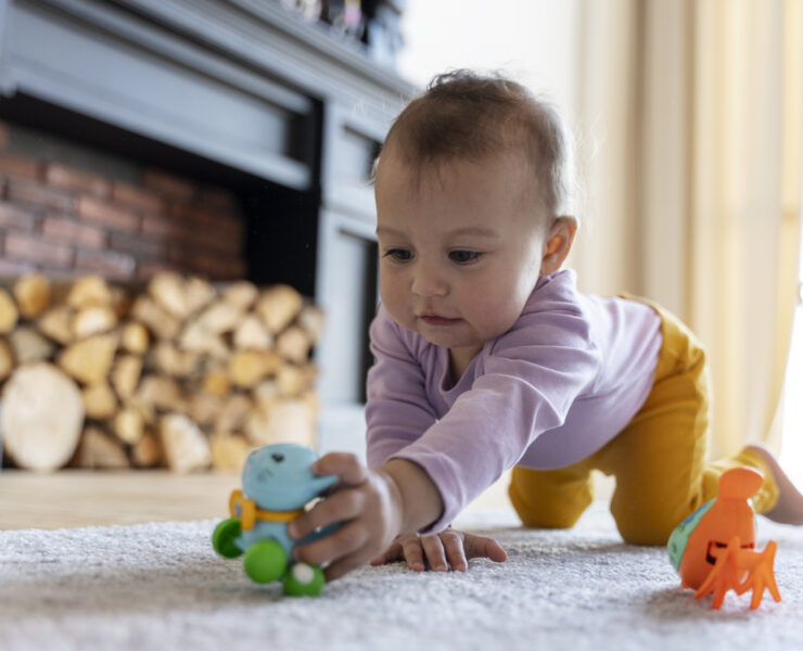 adorable baby playing with toy home floor